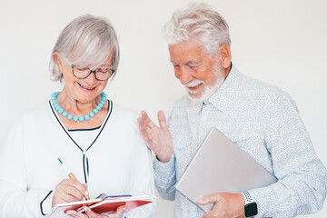 Wall Mural - Mature business people at work consult each other taking note, happy creative team with laptop and notepad