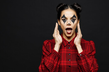 Young woman with Halloween makeup face art mask wear clown costume red dress scream about sales,, hands near mouth isolated on plain solid black background studio portrait Scary holiday party concept