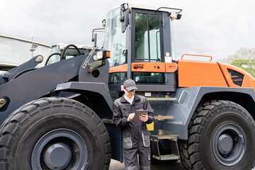 Poster - Serviceman with digital tablet on a background of the tractor.