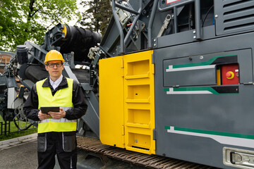 Aufkleber - Engineer with digital tablet next to road construction machine.