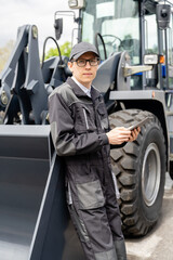 Poster - Serviceman with digital tablet on a background of the tractor.
