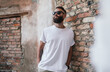 © San4ezz007 - Urban Portrait of Handsome Hipster Man with a Beard Wearing White Blank T-shirt with Space for your Logo or Design. Unique Mockup for Print