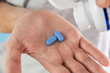 Man pouring a PrEP blue pill from medical bottle in a hand. HIV prevention using Pre-Exposure Prophylaxis medicine. Men health. AIDS prevention concept