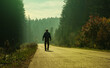 man walking on forest path sunrise