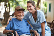 Nurse is providing help and support to elderly man seated in wheelchair. Compassionate care and assistance provided by healthcare professionals to elderly or disabled individuals