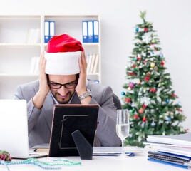 Wall Mural - Young businessman celebrating christmas in the office