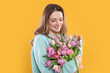 © New Africa - Happy young woman with bouquet of beautiful tulips on yellow background