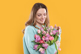 Fototapeta Tulipany - Happy young woman with bouquet of beautiful tulips on yellow background