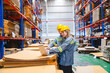© chokniti - Professional worker in safety uniform hard hat, supervisor inspector packaging stock order at factory warehouse, piles of stacking paper manufacture, recycling production industry.