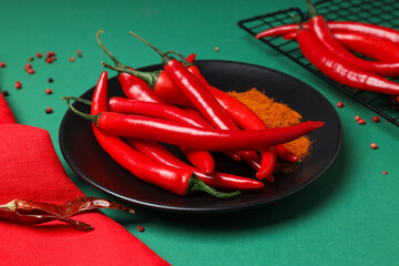 Wall Mural - Hot chili pepper fruits in a plate, on a dark background.