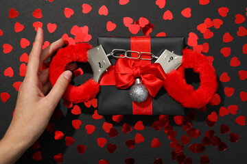 Wall Mural - Handcuffs on a gift box with hearts.