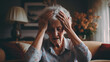 © EmmaStock - Elderly woman person suffering from Alzheimer's hand holding head in the living room