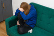 Kobieta płacze, siedzi załamana na sofie w gabinecie psychologa