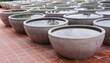 a row of bowls on a red brick floor.