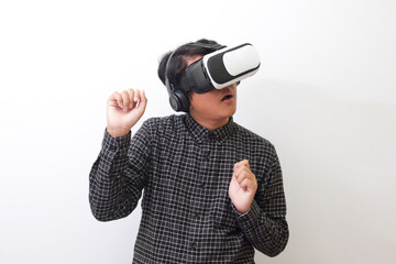 Portrait of Asian man in black plaid shirt using Virtual Reality (VR) glasses and playing racing games and making hand gestures like driving. Isolated image on white background