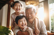 © Anoo - Meeting of grandfather and grandchildren. An elderly Asian man and his grandchildren are happy together. They hug and rejoice at meeting each other. Caring for the elderly. Children visit old people.