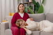 © Parilov - Adult daughter lies on her mother lap, elderly parent mom psychological support and help. Concept Lifestyle family unity and mutual assistance