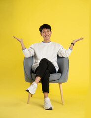 Canvas Print - full body of young Asian man wearing sweater and posing on yellow background