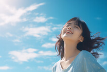 Side View Of A Japanese Girl With A Huge Smile On Her Face Arms Wide Open With Eyes Closed Enjoying A Beautiful Sunny Day Again A Blue Sky