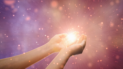 Conceptual Visualization Of Male Or Female Hands Reaching Out In Prayer On Magical Dark Purple Background. Person Connecting With Higher Spiritual Energy Through Bright Light In Their Palms.