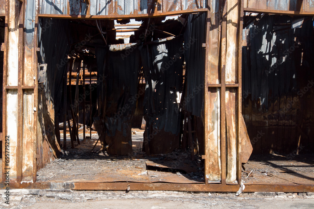 Charred remains of market stalls and metal structures after a fire ...