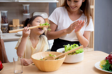 Wall Mural - Happiness asian family with father, mother and daughter preparing cooking salad vegetable food together in kitchen at home, happy dad, mom and kid cooking breakfast with salad, lifestyles concept.