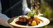 © Anneleven - Steak served by a waiter at a luxury event outdoors, fine dining, post-processed, generative ai