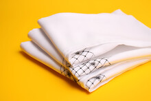 New stylish white handkerchiefs on yellow background close-up