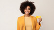 Portrait of happy young woman with afro hair showing credit card while standing on white background