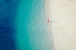 High angle of view of two tourist on wonderful white sandy beach and turquoise ocean, minimalist photo and copy space, Zanzibar in Tanzania.
