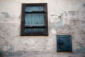 Wall Mural - Closeup of old wooden shutter on ancient building facade on the street