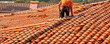 © Michal - Tile roofer on house. Man repair roof from leaking water.