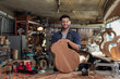 Portrait of guitar luthier small business owner in workroom