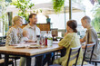 © Halfpoint - Big family with children and a small baby at family dinner in a restaurant.