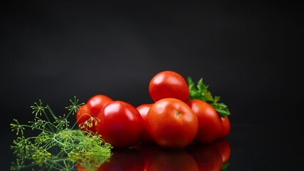 Wall Mural - Ripe red tomatoes with greens, isolated on black background.