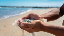  Microplastics Are Contaminated In The Sea. Concept Of Water Pollution And Global Warming,  Concept Of Water Pollution And Global Warming Hands On Beach