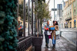 © Marko Geber - Young mixed lesbian couple buying Christmas presents while walking in the city