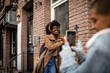 © Marko Geber - Young African American woman getting her picture taken on a smartphone by her lesbian partner in the city