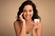 Happy beautiful millennial lady using moisturizing eye cream
