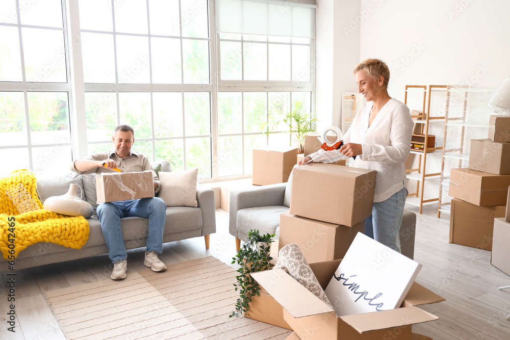 Mature couple packing things in room on moving day