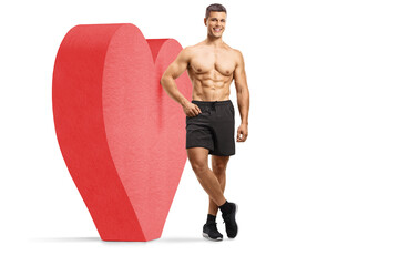 Poster - Full length portrait of a shirtless muscular guy leaning on a red heart