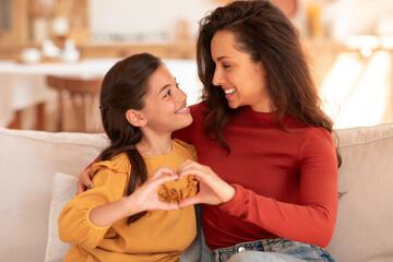 Wall Mural - Happy Mother And Daughter Holding Hands In Heart Shape Indoor