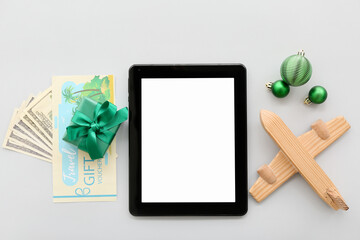 Sticker - Tablet computer with wooden airplane and Christmas decor on light background