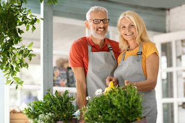 Portrait Of Happy Mature Man And Woman Gardening Together At Country House