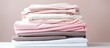 Freshly washed and ironed white and pink fabric stack or pile suitable for textile retail or laundry services with a soft appearance