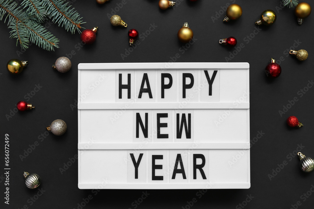 Text HAPPY NEW YEAR with Christmas balls on black background