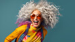 Beautiful senior woman with long curly grey hair in colorful clothes laughing moving. Active lifestyle positive mindset fashion concept