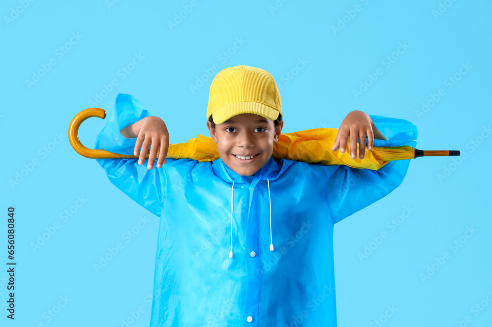 African-American little boy with umbrella on blue background