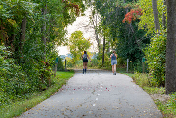 Wall Mural - A Jogger And A rollerblader Enjoying A Fall Day On The Fox River Trail Near De Pere, Wisconsin