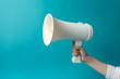 © Canities - Hand holding megaphone isolated on blue background with copyspace. Advertisement mock up, clip art, announcement and communication creative banner background concept